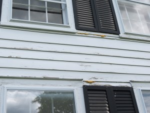 Peeling paint on siding, old metal shutters